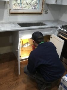 Installing pipe under kitchen sink